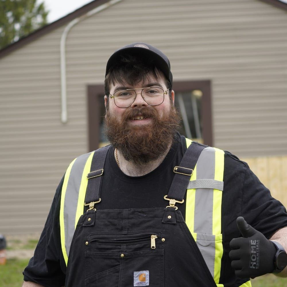 A Lambton Maintenance Men crew member in work gear giving a thumbs up