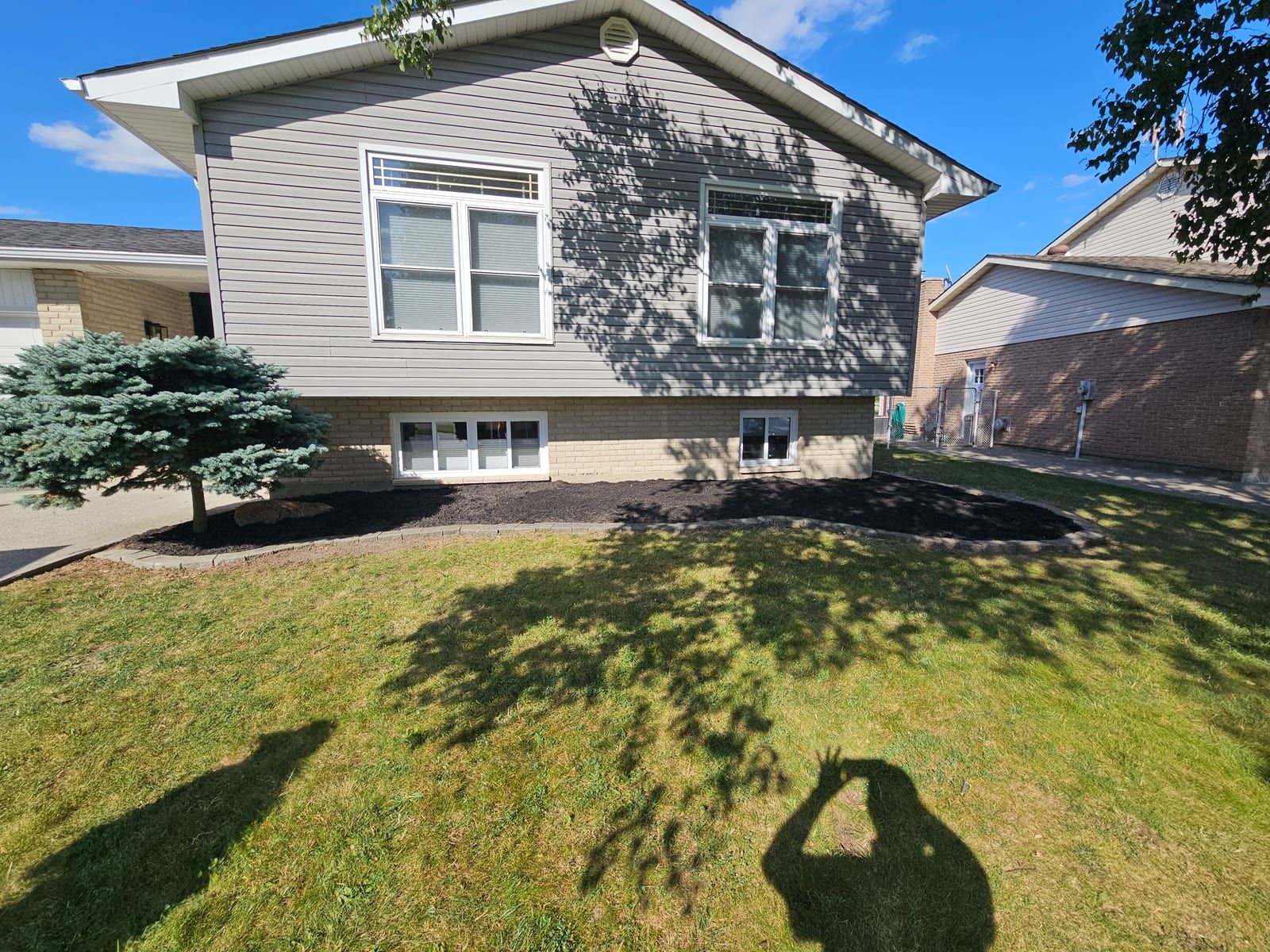 Fresh mulch beds and a mowed lawn across the front of a home after a full property cleanup