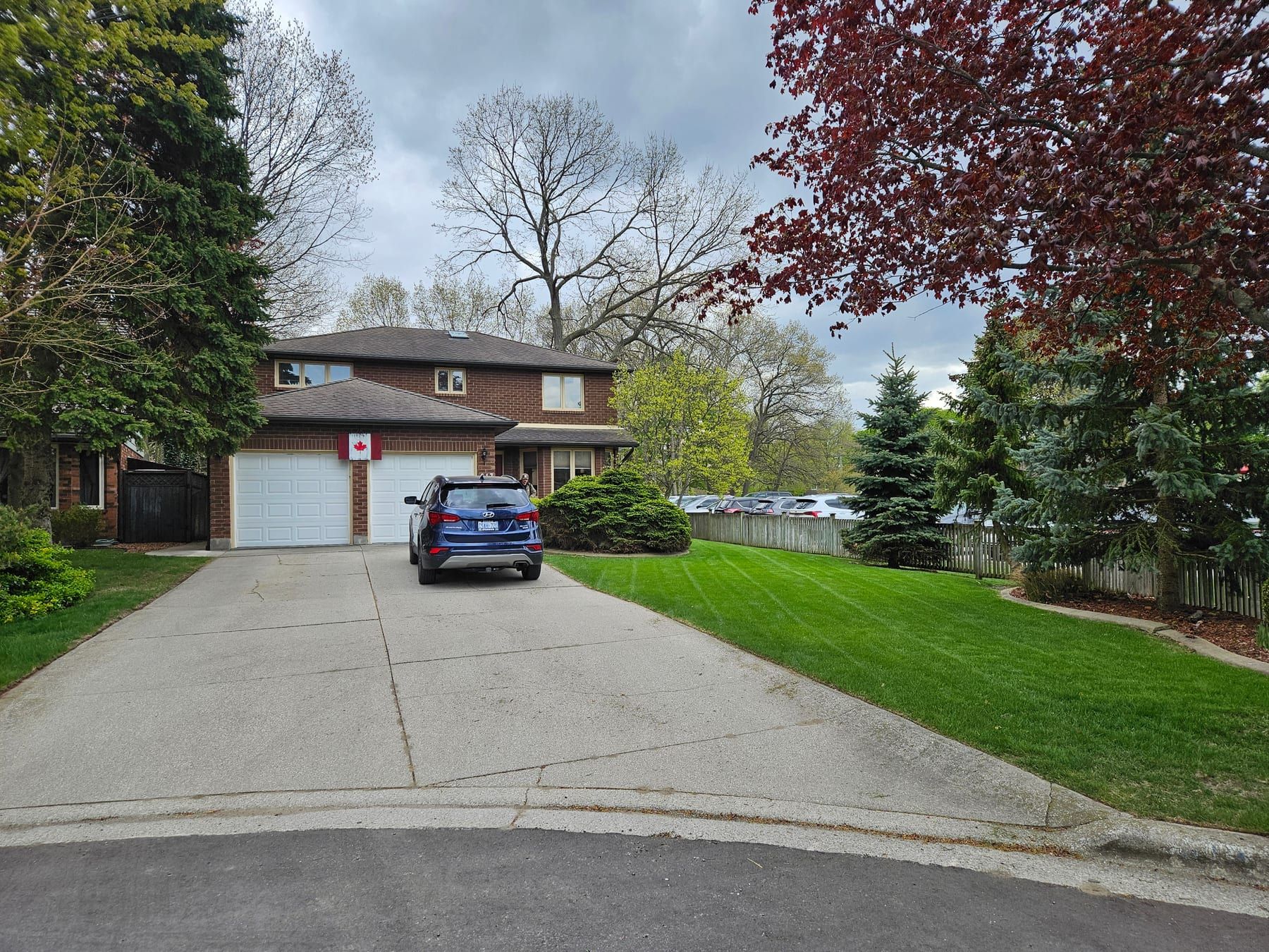 A freshly mowed front lawn with clean mowing stripes beside a brick home