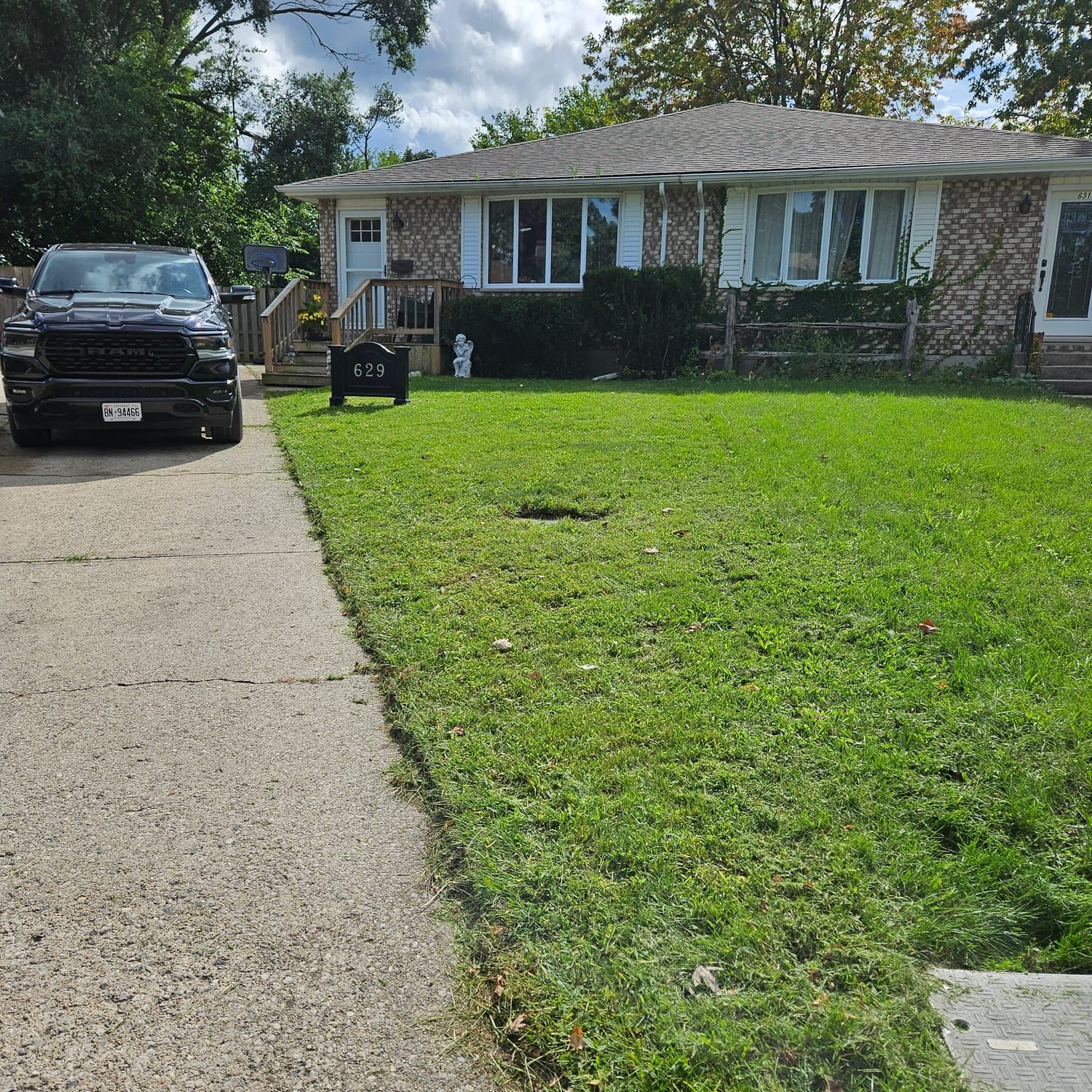 A freshly cut front lawn beside a driveway