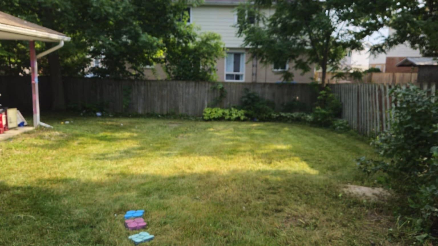 The same back garden cut back and mowed, with the stepping stone path uncovered again