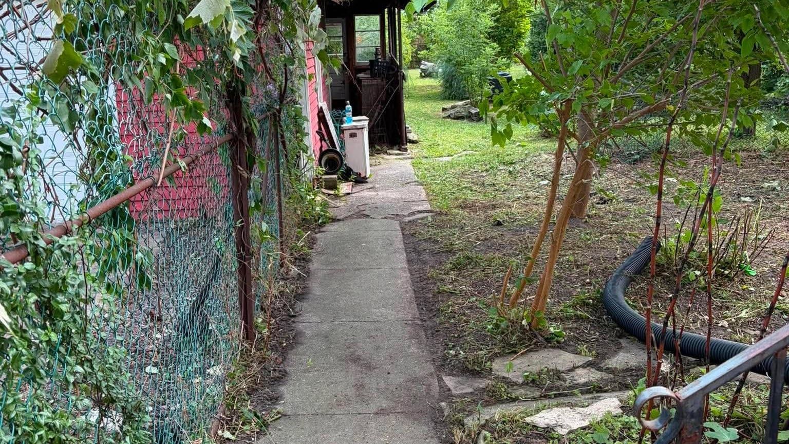 The same walkway cleared end to end and usable again, with the fence line cut back