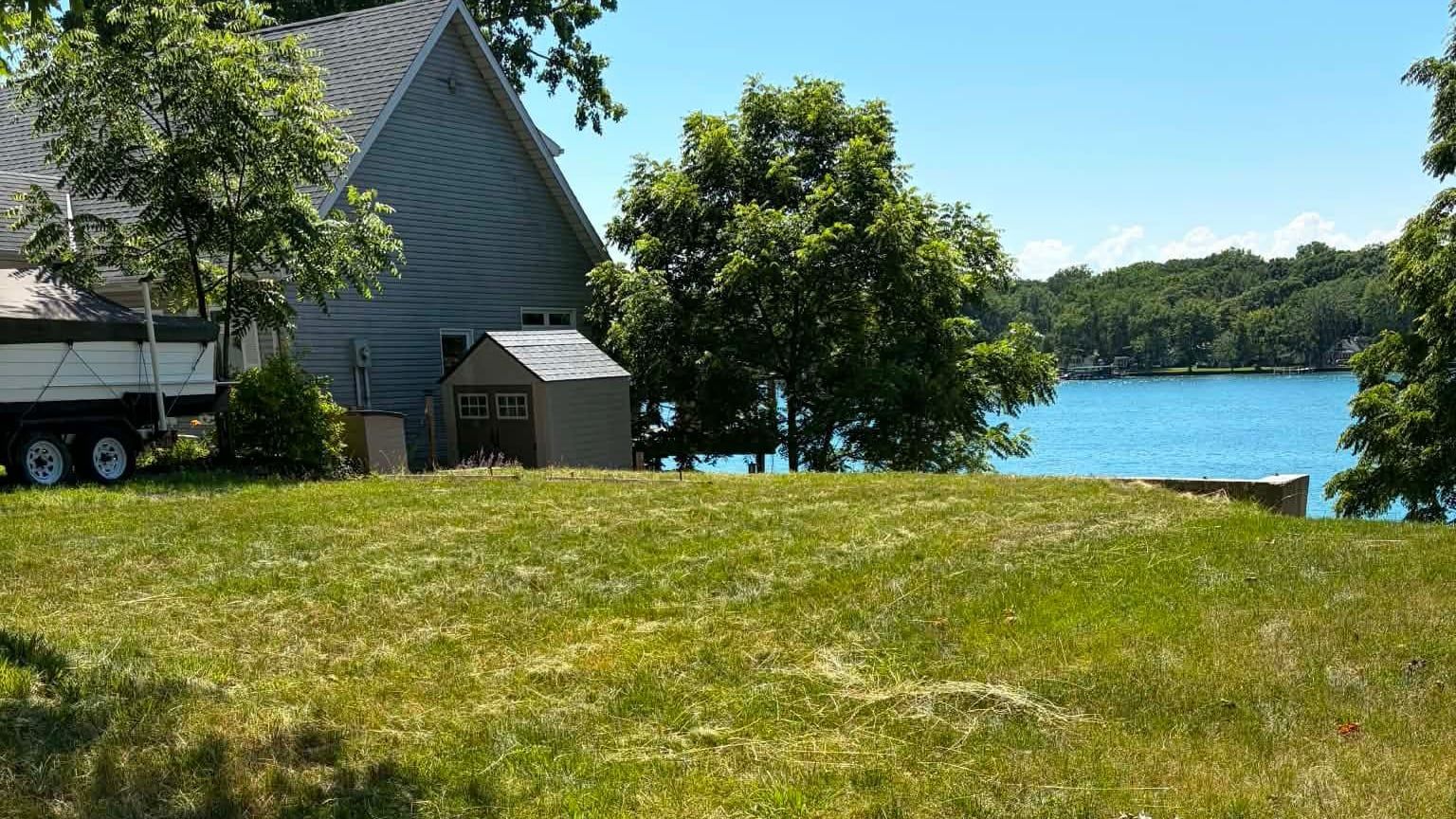 The same riverfront lawn cut back and mowed level, with the water beyond